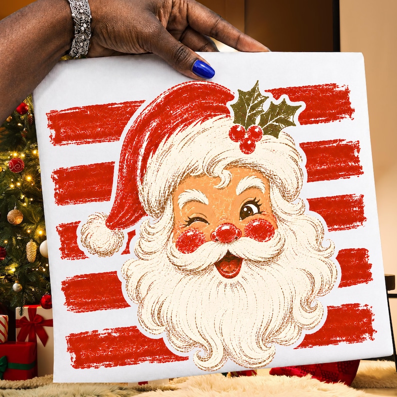 May include: A square white canvas featuring a graphic illustration of a winking Santa Claus with a red hat, rosy cheeks, and a white beard. The background consists of horizontal red brushstroke stripes, and a sprig of holly is placed on the hat.