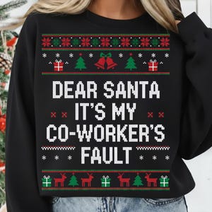 May include: Black Christmas sweater with the text "DEAR SANTA IT'S MY CO-WORKER'S FAULT". The sweater has a festive design with red, green, and white accents, including gift boxes, bells, and reindeer.