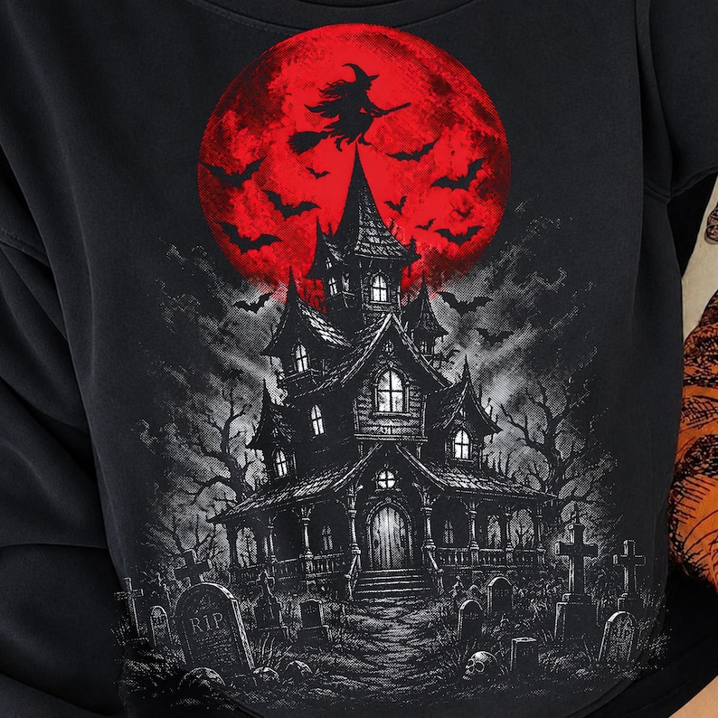 May include: A black sweatshirt featuring a graphic print of a haunted house in a graveyard under a large red moon. The design includes a silhouette of a witch flying on a broomstick, numerous bats, bare trees, and tombstones with the text RIP.