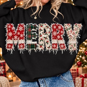 Può includere: Una felpa nera a maniche lunghe con la scritta MERRY sul petto. Ogni lettera è composta da toppe di tessuto con bordi sfrangiati, che mostrano motivi a fiocchi di neve rossi, tartan verde e bacche di agrifoglio con dettagli in pizzo.