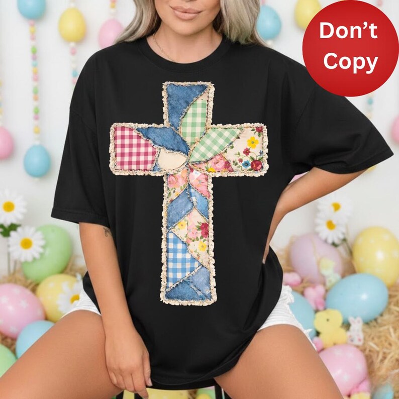 May include: Black t-shirt with a patchwork cross design. The cross is made from various fabric patterns, including gingham, floral, and denim-style textures. The shirt is a casual, oversized style.