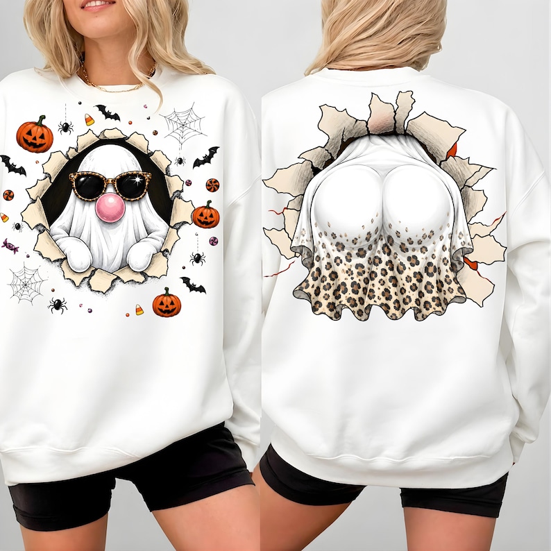 May include: A white long-sleeve sweatshirt featuring a front and back graphic print. The front shows a ghost wearing leopard print sunglasses and blowing a pink bubble, surrounded by pumpkins, spiders, and webs. The back shows a ghost rear view.
