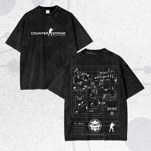 May include: Dark grey t-shirt with the text "COUNTER STRIKE GLOBAL OFFENSIVE" and a player graphic. The back shows a map labeled "DUST II" with text and graphics. The shirt has a faded, vintage look.