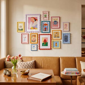 Può includere: Una parete galleria con dodici cornici colorate dai bordi smerlati in varie dimensioni e tonalità, tra cui giallo, lavanda, rosso e blu, che circondano diverse stampe artistiche illustrative di cibo, animali e scene d'interni.