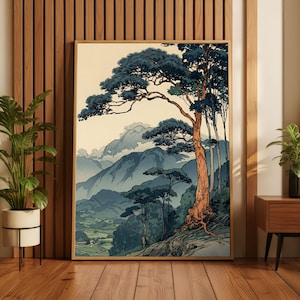 May include: A framed wall art print featuring a landscape illustration with a large, prominent pine tree in the foreground, rolling blue mountains in the distance, and a valley below, rendered in a muted color palette of blue, green, and tan.