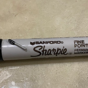 May include: A black and white Sharpie fine point permanent marker with the brand name "SANFORD" printed on the side.