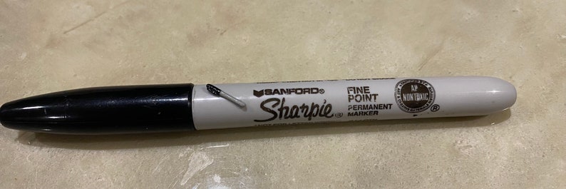 May include: A black and white Sharpie fine point permanent marker with the brand name "SANFORD" printed on the side.