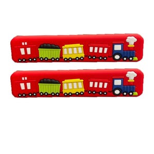Puede incluir: Dos estuches rojos con un diseño de tren colorido. Cada estuche presenta un tren con un vagón de carbón, un vagón de pasajeros amarillo y una locomotora azul. El diseño es de colores brillantes, lo que lo hace atractivo para los niños.