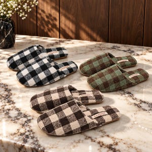 May include: Three pairs of slip-on slippers featuring a checkered pattern in black and white, green and brown, and dark brown and beige. Each slipper has a rounded toe, a flat sole, and a small rectangular label with the text LSAOSEE.