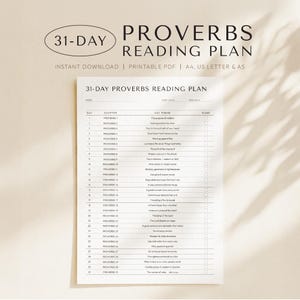 May include: A white ceramic mug with a black handle and the text "But First, Coffee" in a black, handwritten-style font. The mug is on a white surface.