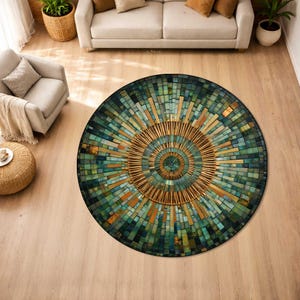 May include: A round area rug with a mosaic design. The rug features a central sunburst pattern in gold and brown tones, surrounded by a field of teal, green, and gold rectangular tiles. The rug is placed on a light wood floor.
