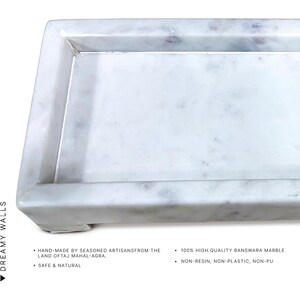 May include: A rectangular white marble tray with a raised edge. The tray is hand-made from Banswara marble and is safe and natural. The text on the image says "Dreamy Walls".