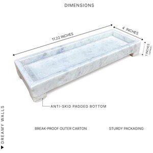 May include: A rectangular marble tray with a light grey and white veined pattern. The tray is 28.5 cm long, 10.2 cm wide, and approximately 2.5 cm high. It has an anti-skid padded bottom. The text "DIMENSIONS" is visible.