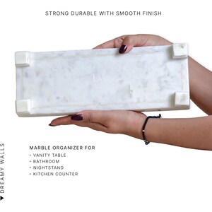 May include: A white marble organizer with a smooth finish, held by hands. The text reads "Strong Durable with Smooth Finish" and "Marble Organizer for Vanity Table, Bathroom, Nightstand, Kitchen Counter."