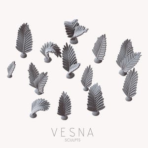 May include: A collection of gray, fern-shaped sculptures arranged on a white background. The sculptures have detailed leaf patterns and are mounted on small, round bases. The text "VESNA SCULPTS" is displayed in a minimalist font below the sculptures.