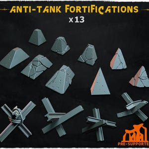 May include: A collection of 13 gray anti-tank fortifications, including pyramid-shaped obstacles and metal beam structures. The text "ANTI-TANK FORTIFICATIONS" and "x13" are displayed in yellow. The image also includes the text "PRE-SUPPORTED".
