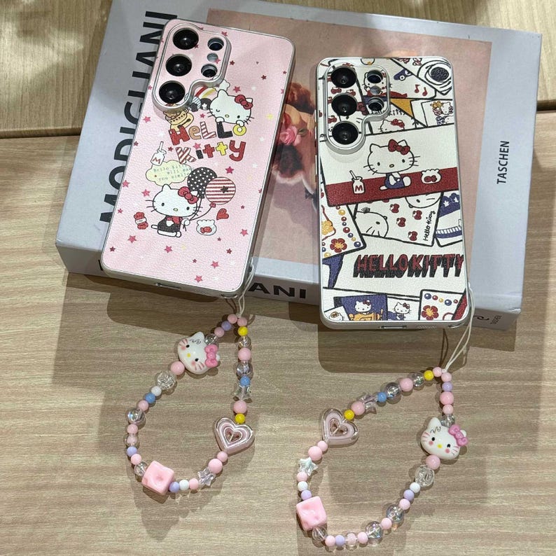 Peut inclure: Deux coques de t&eacute;l&eacute;phone avec des motifs Hello Kitty. L'une est rose avec des graphiques et du texte Hello Kitty, l'autre est blanche avec un collage d'images Hello Kitty. Deux bracelets de poignet assortis en perles avec des breloques Hello Kitty et des c&oelig;urs.