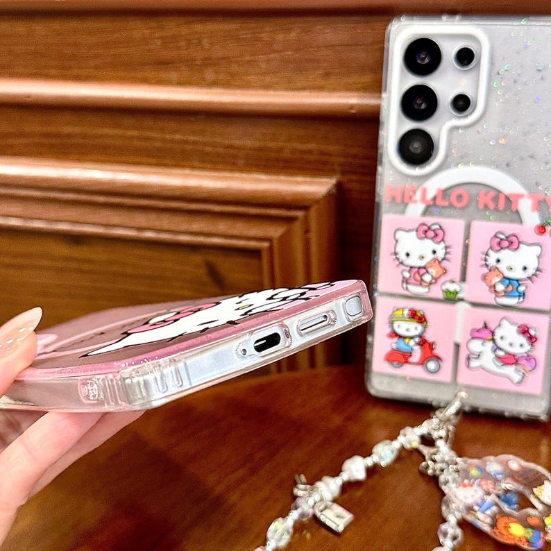 Peut inclure: Coque de t&eacute;l&eacute;phone transparente avec un motif Hello Kitty rose. Le bo&icirc;tier a un cadre argent&eacute; et un dos transparent &agrave; effet paillet&eacute;. Le motif comprend plusieurs images de Hello Kitty sur fond rose.