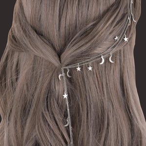 Puede incluir: Accesorio plateado para el cabello con cadenas delicadas, adornos de estrellas y medias lunas. Diseñado para usar en el cabello, añade un toque celestial a cualquier peinado. Cabello castaño claro. Un accesorio decorativo para el cabello.