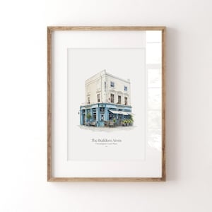 May include: Framed watercolor print of a building with a blue facade and awning, labeled "The Builders Arms". The building has multiple windows and a light-colored exterior. The print is in a wooden frame.