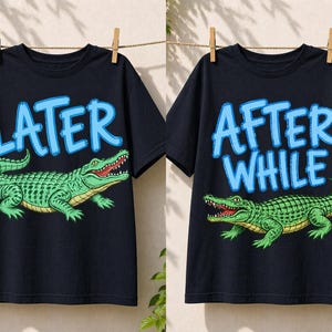 May include: Two navy blue t-shirts are displayed, each with a different design. One shirt has the word "LATER" in light blue above a green alligator. The other shirt has the words "AFTER WHILE" above a green alligator.