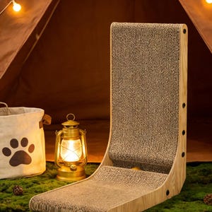 May include: A cat scratching post with a curved design. The post is made of wood and corrugated cardboard. A canvas bag with a paw print and a vintage lantern are in the background. The scene is set on a bed of green moss.