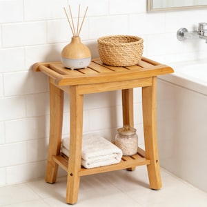 May include: A bamboo bathroom stool with a slatted top and a lower shelf. The stool holds a small woven basket, a diffuser with reeds, a folded white towel, and a jar of bath salts. The stool is approximately 18 inches tall.