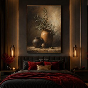 May include: A bedroom scene featuring a large painting of olive branches in a terracotta vase. The bed has a black headboard, dark gray pillows, and red and gold accent pillows. A red blanket covers the bed, and there are hanging pendant lights.