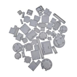Peut inclure: Une collection de petits composants miniatures en résine grise non peinte, présentant divers designs industriels, notamment des trappes circulaires, des portes rectangulaires, des grilles de ventilation et des panneaux structurels pour décors de jeux.