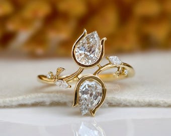 IGI-certifierad naturinspirerad päronförlovningsring med diamanter i klusterfatt, blad- och kronbladsdesign, redo att skickas