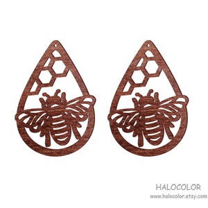 May include: A pair of wooden earrings shaped like teardrops with a honeycomb pattern and a bee cutout. The earrings are a dark brown color.