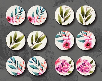 May include: Set of 12 laser cut wood charms featuring floral and leaf designs. The charms are round and have a white background with pink and green watercolour illustrations. The charms are perfect for adding a touch of nature to your crafts.