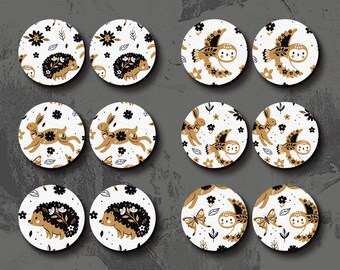 Può includere: Set di 12 ciondoli in legno tagliati al laser con vari animali del bosco e motivi floreali. I ciondoli sono rotondi e hanno uno sfondo bianco con dettagli dorati e neri. Gli animali includono un riccio, un gufo, un coniglio e una farfalla.