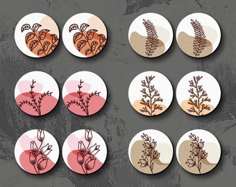 Op de afbeelding: Set van 12 lasergesneden houten bedels met verschillende bloemmotieven. De bedels zijn in tinten bruin, roze en wit. De ontwerpen omvatten bladeren, takken en bloemen. De bedels zijn perfect om een ​​natuurlijke touch aan je knutselwerk toe te voegen.