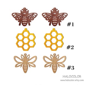 May include: Three different wood cutout designs for earrings. The first design is a brown bee with wings. The second design is a yellow honeycomb. The third design is a brown bee with wings. The designs are labeled #1, #2, and #3.