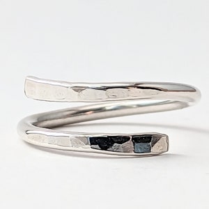 May include: A silver hammered metal ring with a twisted design.