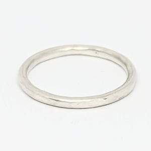May include: A simple silver band ring with a hammered texture.