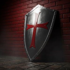 May include: A silver shield featuring a red cross, positioned against a red brick wall. The shield has a riveted edge and a slightly aged look. The cross is centrally placed, creating a strong visual impact. The scene evokes a historical or medieval setting.