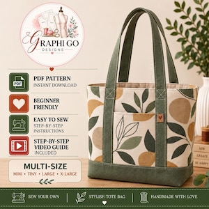 May include: A tote bag featuring a cream-coloured fabric with a pattern of dark green leaves and tan circles. The bag has dark green canvas handles and a matching base. A small brown square tag with a heart icon is attached to the front pocket.