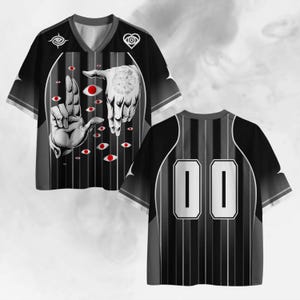 Puede incluir: Camiseta de béisbol negra y gris con cuello en V y mangas cortas. La parte delantera presenta un gráfico de dos manos con diseños de ojos rojos y un diseño circular. La parte trasera muestra el número "00" en blanco.