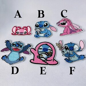 K&ouml;nnte beinhalten: Gestickte Aufn&auml;her mit der Figur Stitch und seiner Begleiterin Angel. Die Aufn&auml;her sind in verschiedenen Posen und Farben, darunter Blau, Rosa und Wei&szlig;. Jeder Aufn&auml;her ist mit einer Kontrastfarbe umrandet und mit einem Buchstaben versehen.