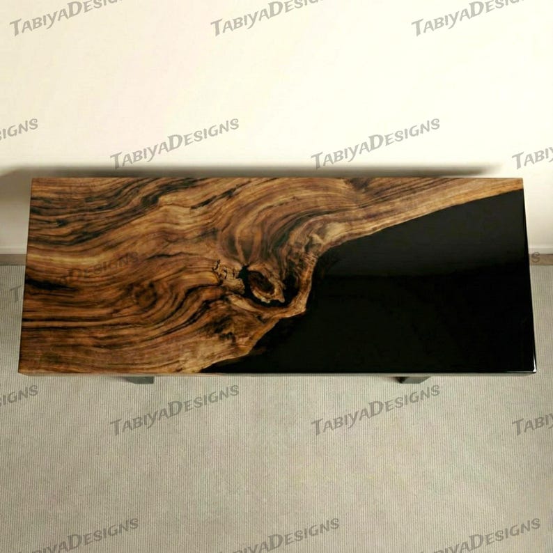 May include: A rectangular coffee table with a live edge wood top and a black resin inlay. The wood features a natural grain pattern in shades of brown and tan. The table has metal legs.