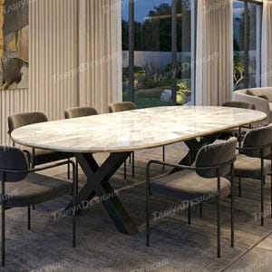 Peut inclure: Une table de salle à manger ovale avec un plateau clair à motifs et une base en métal noir. La table est entourée de six chaises rembourrées grises avec des cadres en métal noir. La pièce a de grandes fenêtres et des rideaux aux tons neutres.