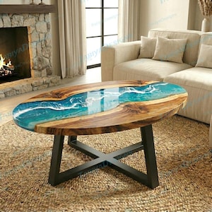 May include: Oval coffee table with a wooden frame and a blue and white resin river design. The table has a black metal base and sits on a woven rug. The table's dimensions are approximately 48 inches long and 24 inches wide.