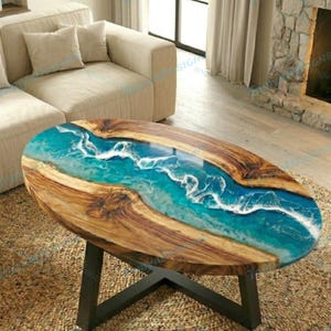 May include: Oval coffee table with a wooden frame and a blue and white resin river design. The table has a black metal base and is set on a woven rug. The table's dimensions are approximately 48 inches long and 24 inches wide.