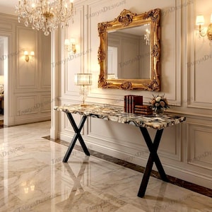 May include: A luxurious entryway featuring a marble-topped console table with black X-shaped legs. A large gold ornate mirror hangs above the table. The room is decorated with a chandelier and sconces.