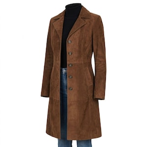 以下が含まれることがあります： クラシックなデザインの、長い茶色のスエードコート。ノッチドラペルカラー、ボタン留め、テーラードフィットが特徴です。黒のタートルネックとブルージーンズの上に着用されています。