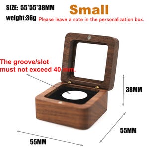 Puede incluir: Una peque&ntilde;a caja de madera abierta con tapa transparente, que mide 5,5 cm x 5,5 cm x 3,8 cm. La caja tiene un interior negro y una ranura que no debe exceder los 40 mm. El peso es de 36 g. El texto "Small" es visible.