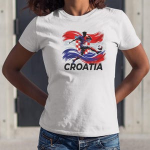 A white t-shirt with a graphic design depicting a soccer player in action, along with the word "Croatia" printed below.