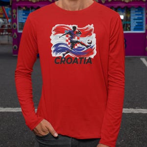 A red long-sleeved shirt with a graphic of a soccer player kicking a ball, along with the word "Croatia" printed on it.